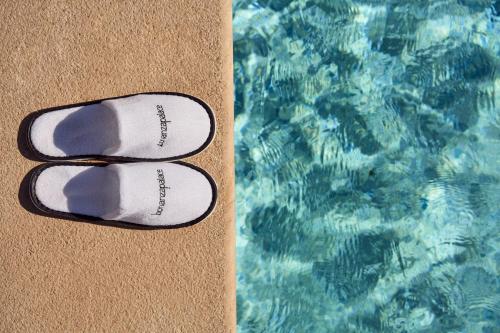a pair of flip flops next to a swimming pool at Palace Bonanza Playa Resort & SPA by Olivia Hotels Collection in Illetas