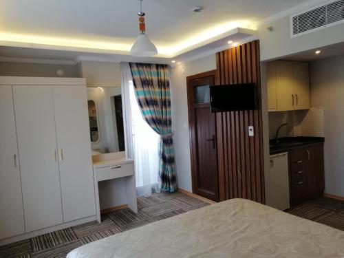 a large bedroom with a bed and a kitchen at Alya Suite Rezidans in Trabzon