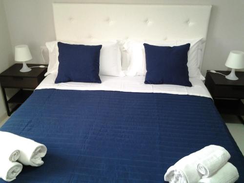 a blue and white bed with blue sheets and pillows at Appartamento Galeotti 18 in Gubbio