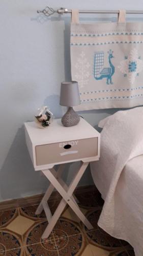 a bedside table with a lamp on top of a bed at 4 stagioni in Villasimius