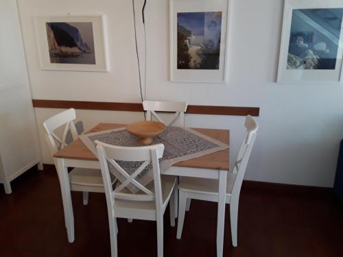 a dining room table and chairs with paintings on the wall at loft sul mare Sirolo in Sirolo