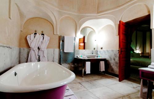a large bathroom with a tub and a sink at Palais Faraj Suites & Spa in Fès