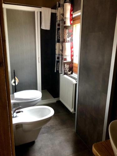 a bathroom with a white toilet and a sink at Chalet Saint-Barthélemy Hotel in Nus