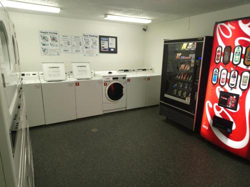 a laundry room with a refrigerator and washing machines at InTown Suites Extended Stay Dallas TX - Medical Center in Dallas