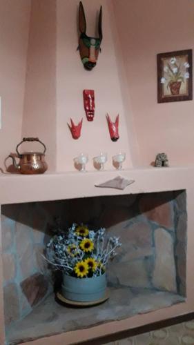 a shelf with a fireplace with a pot of flowers at 4 stagioni in Villasimius