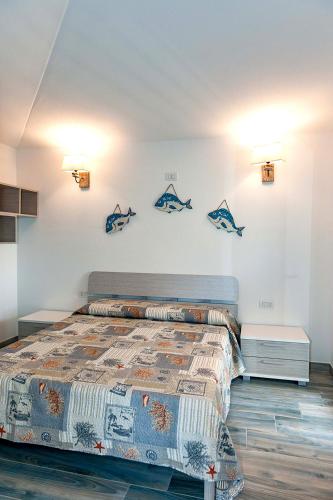 a bedroom with a bed and some fishes on the wall at VILLA PARADISE in Budoni