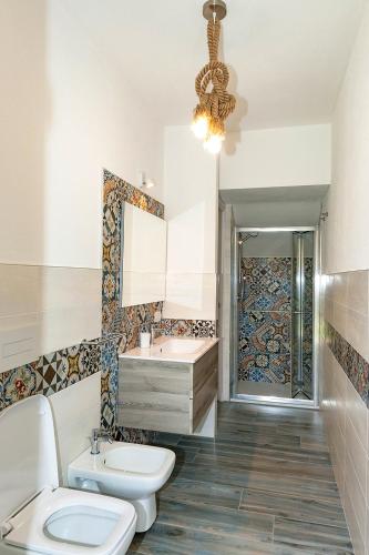 a bathroom with a toilet and a sink at VILLA PARADISE in Budoni