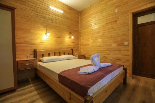 a bedroom with a bed in a wooden room at Tunays Pansiyon in Cıralı