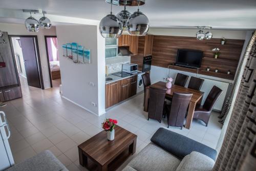 a kitchen and living room with a table and a couch at Neptun Blue Apartament in Neptun