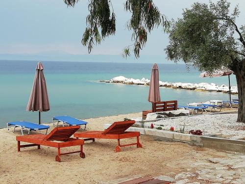 a group of chairs and umbrellas on a beach at Marti Resort in Skala Sotiros