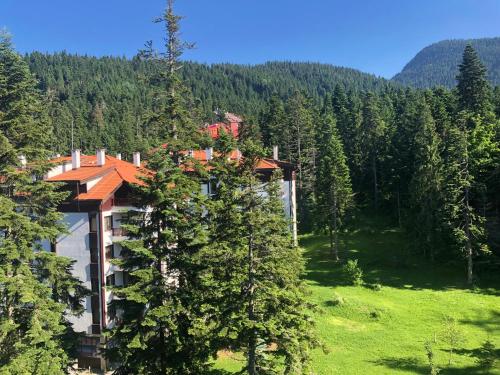a building in the middle of a field with trees at Deluxe 707 in Borovets