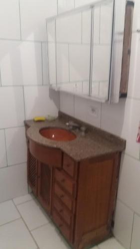 a bathroom with a red sink and a mirror at casa de temporada coroados in Guaratuba