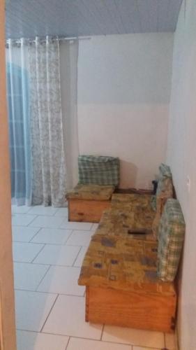 a living room with two chairs and a table at casa de temporada coroados in Guaratuba