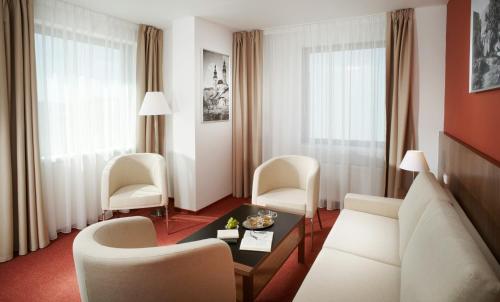 a living room with a couch and chairs and a table at Clarion Congress Hotel České Budějovice in České Budějovice