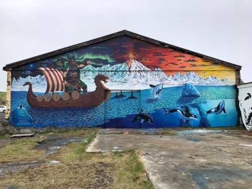 a mural on the side of a building with dolphins at The Bookstore Family Apartment in Hellissandur