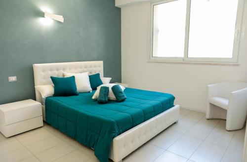 アルゲーロにあるThe Smeraldのベッドルーム1室(青いシーツと窓付)