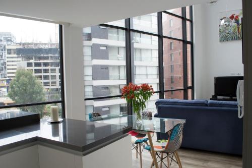 uma sala de estar com um sofá azul e uma mesa de vidro em ESPECTACULAR LOFT em Quito