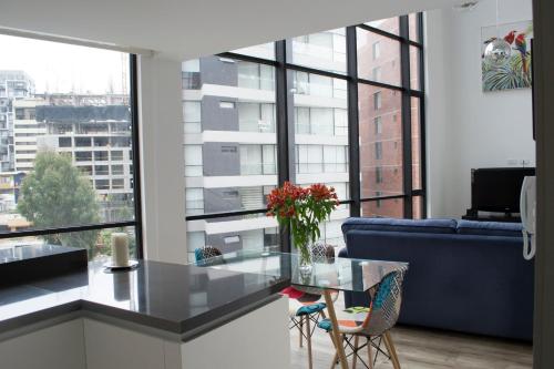 a living room with a blue couch and a glass table at ESPECTACULAR LOFT in Quito