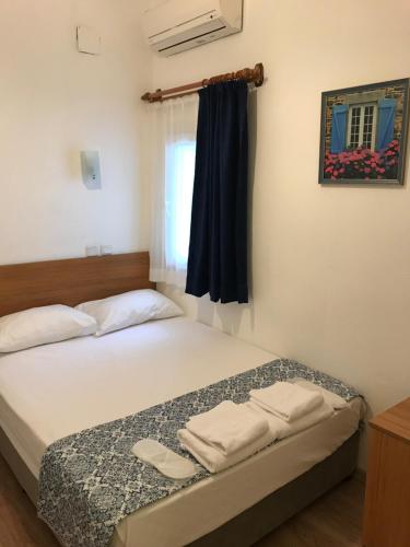 een slaapkamer met een bed met twee handdoeken erop bij Tay Pansiyon in Bodrum City