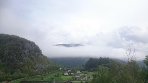 a foggy valley with a small town in the middle at Dada Apartment in Hjelmeland