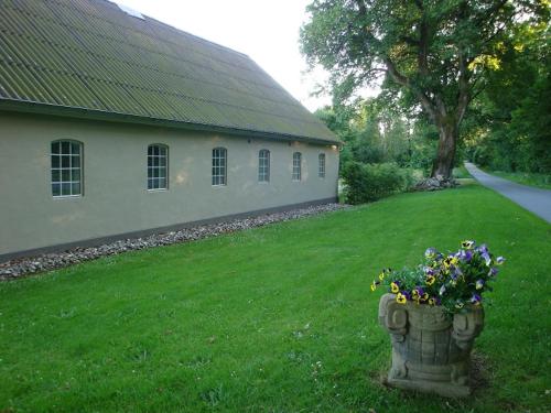 a pot of flowers in a yard next to a building at Engelsholm Bed & Breakfast in Bredsten