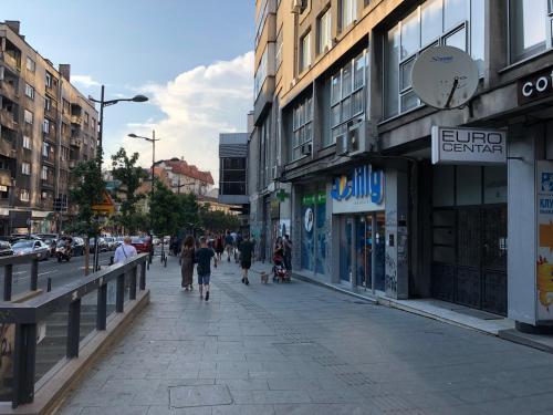 um grupo de pessoas andando por uma rua com edifícios em Aria Royal apartment em Belgrado