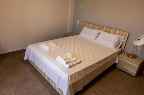 a bedroom with a bed with two towels on it at Tsoutsis Apartments in Marantochori