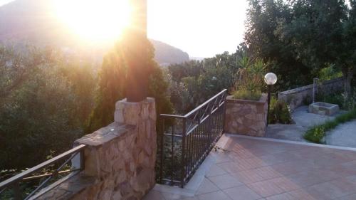a balcony with a stone railing with the sun shining at Case Susinna in Capaci
