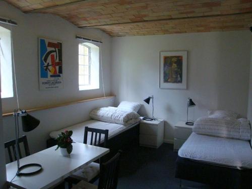 een kamer met 2 bedden, een bureau en een tafel bij Engelsholm Bed & Breakfast in Bredsten