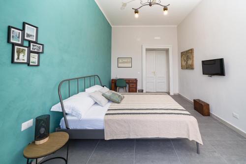 Un dormitorio con una cama y un televisor en una pared. en N'Art Suites - Napoli, en Nápoles