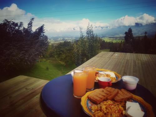 a plate of food on a table with orange juice at Cabaña Agrreste in Nemocón