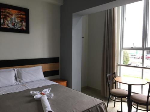 Un dormitorio con una cama y una mesa y una ventana. en Hostal Parisuite, en Lima