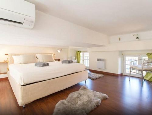 - une grande chambre blanche avec un lit et une table dans l'établissement Aida - rue Bosio, à Nice