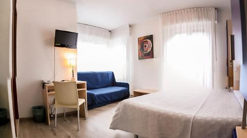 a bedroom with a bed and a blue couch at Hotel Alpino in Malcesine