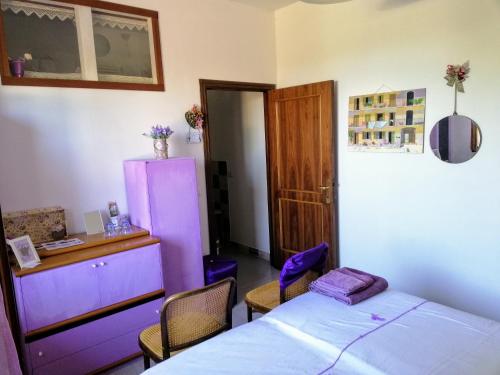 チンゴリにあるAmor di Lavandaのベッドルーム(ベッド1台、紫色の冷蔵庫付)