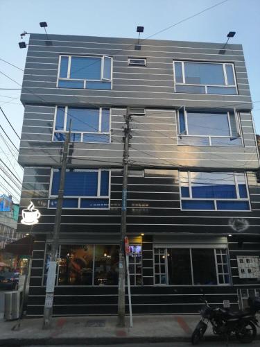 a building with blue windows and a motorcycle parked in front at Hotel Casa Huesped Kiwi in Bogotá