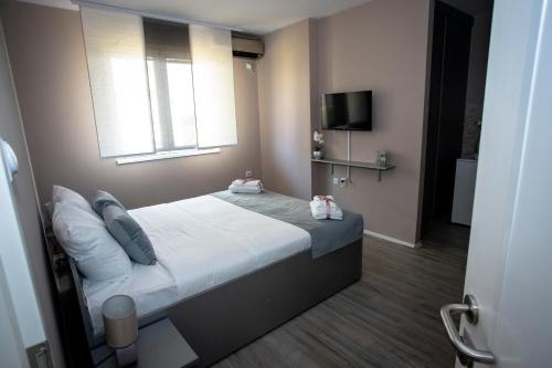 Un dormitorio con una cama con ventana y un televisor. en Venus, en Niš
