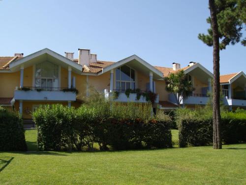 a house with a palm tree in a yard at Aldeamento Turistico Casas da Comporta in Comporta