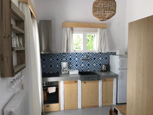 eine kleine Küche mit einem Waschbecken und einem Fenster in der Unterkunft Manolis' House in Skiathos-Stadt