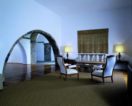 a room with two chairs and a table and an archway at Convento de São Francisco in Vila Franca do Campo