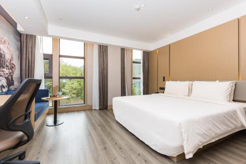 1 dormitorio con 1 cama blanca grande y escritorio en Atour Yan'an Zaoyuan Hotel en Yan'an