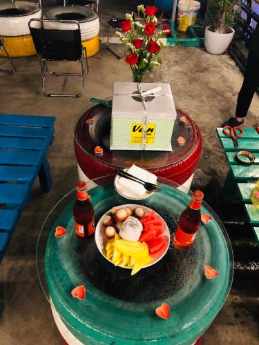 a plate of food on a table with a bowl of fruit at Peaceful House Hostel in Dong Hoi