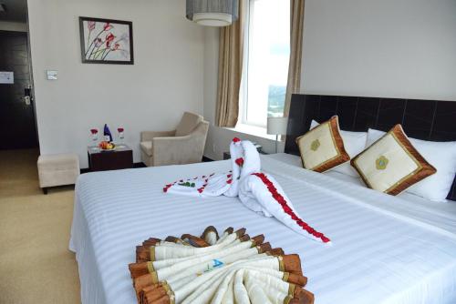 a hotel room with a bed with a stuffed animal on it at Sai Gon Ban Me Hotel in Buon Ma Thuot