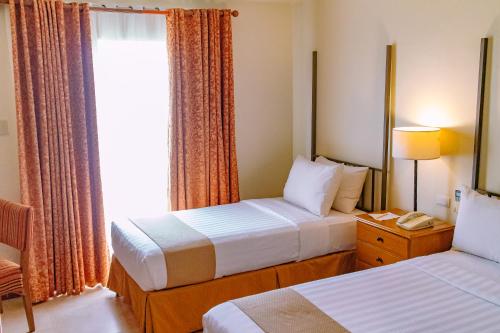 Cette chambre comprend 2 lits et une fenêtre. dans l'établissement Crown Regency Prince Resort, à Boracay