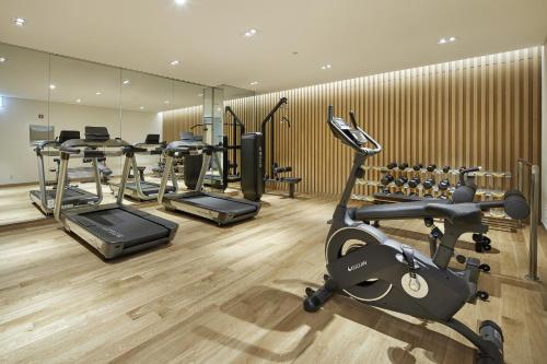 um ginásio com várias bicicletas de exercício e máquinas de andar em MD HOTEL DOKSAN - Fomerly Staz Hotel Doksan em Seul
