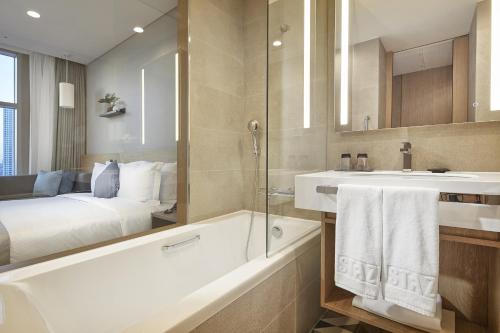 baño con bañera y lavamanos y cama en MD HOTEL DOKSAN - Fomerly Staz Hotel Doksan en Seúl