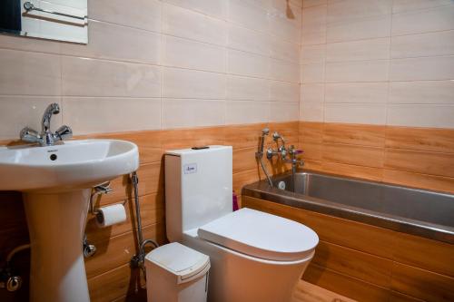 een badkamer met een wastafel, een toilet en een bad bij Nepal Pavilion Inn in Kathmandu