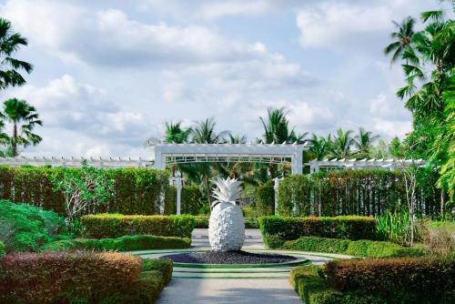 a statue in the middle of a garden with a fountain at The Sanchaya in Lagoi