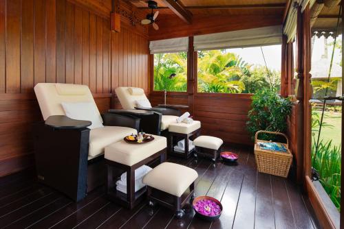 a screened in porch with chairs and a table at The Sanchaya in Lagoi