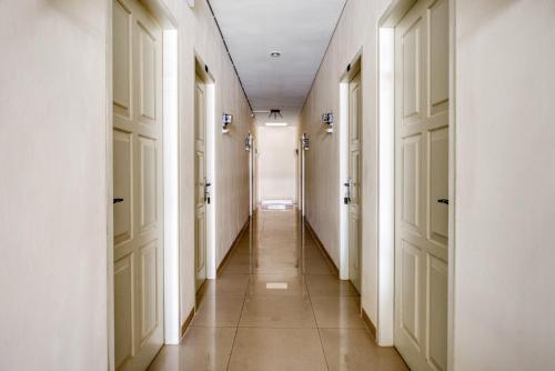 a hallway with white doors and a tile floor at RedDoorz near Ciputra World 3 in Surabaya